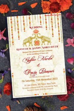 A Wedding Invitation Card Full of Golden Grandeur With Garlands Of Marigold Flowers, Majestic Elephants  And A Pink Lotus